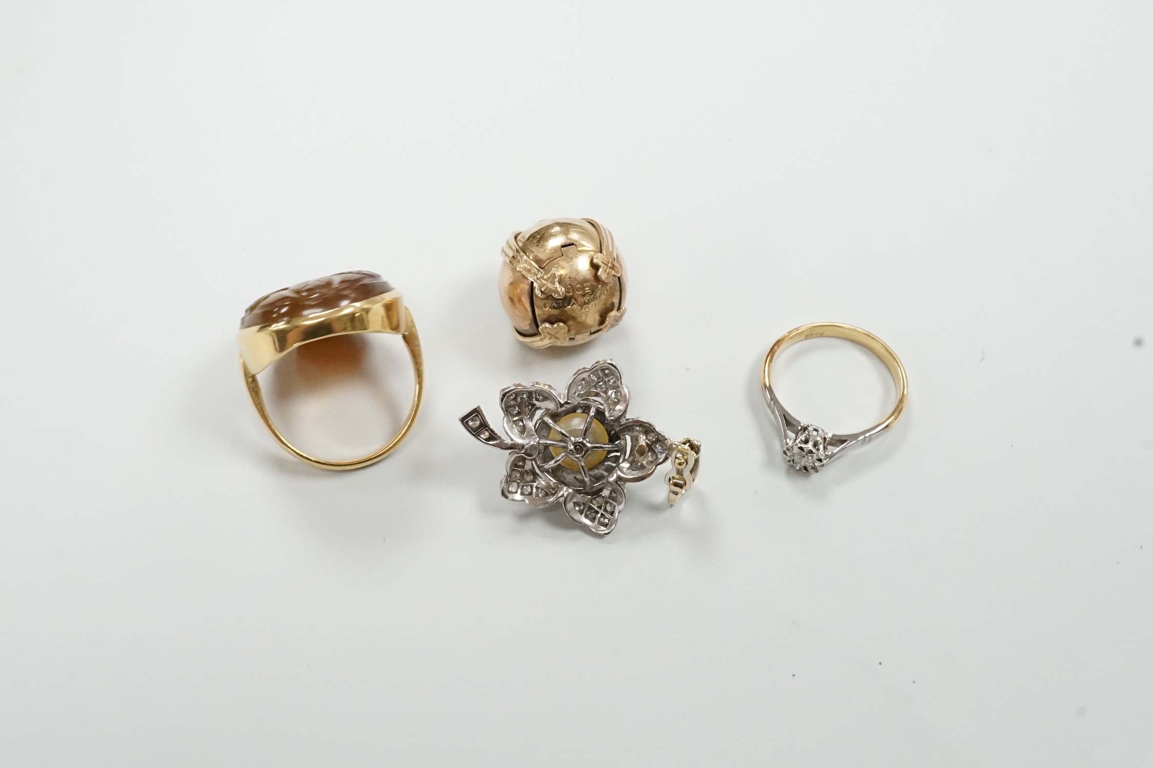 A 9ct masonic ball pendant, 18mm, a 750 white metal cultured pearl and diamond chip set flower head pendant, 38mm, a yellow metal ring and an 18ct and illusion set diamond ring.
